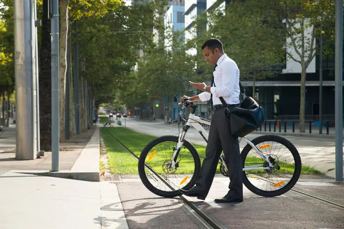Trabajador de oficina con bici aportando a la movilidad sostenible en bicicleta rumbo al trabajo Bogotá